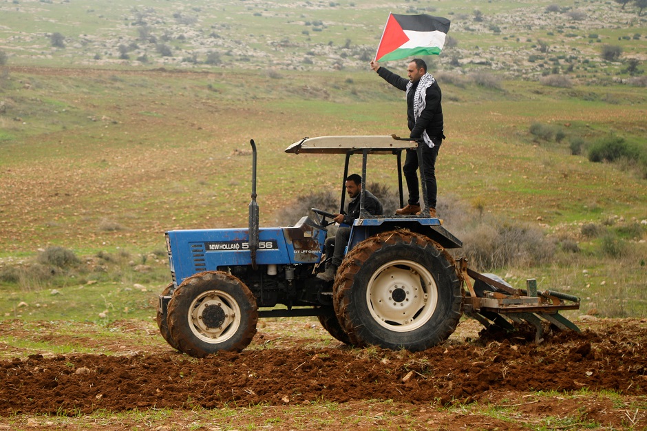 A demonstrator holding a Palestinian flag rides on a tractor during a protest against the U.S. president Donald Trump's Middle East peace plan, PHOTO: REUTERS