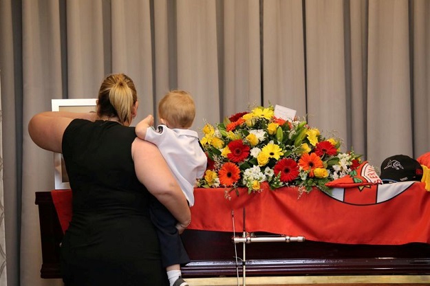 Mourners stand near the coffin of late RFS volunteer Keaton during his funeral in Buxton. PHOTO: AFP