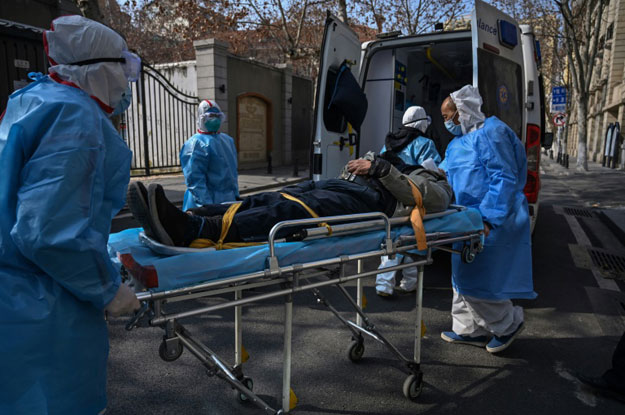 Medical staff in protective clothing carry a suspected virus patient from an apartment in the central Chinese city of Wuhan, the epicentre of the outbreak. PHOTO: AFP