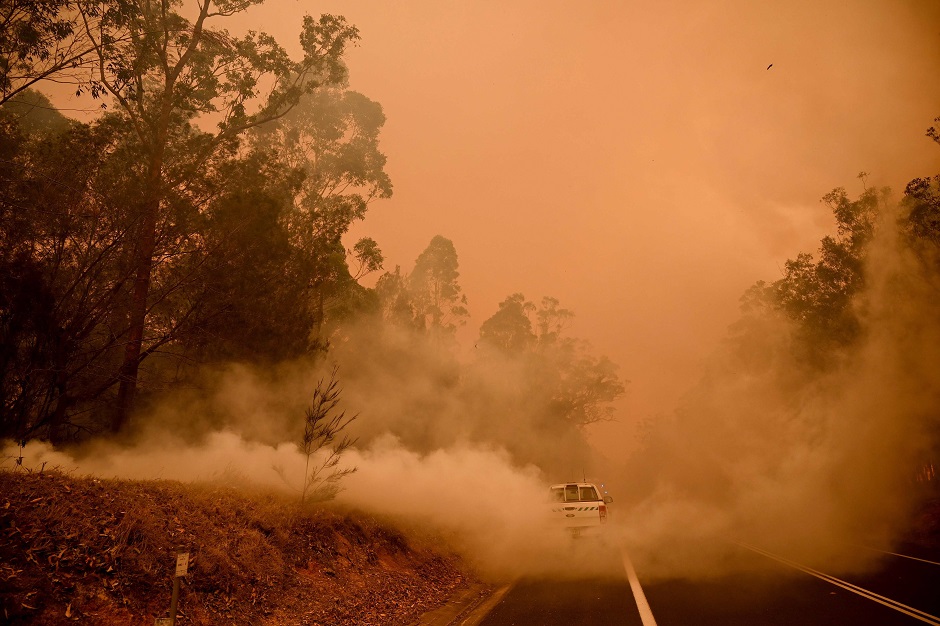 Firefighters tackle a bushfire in thick smoke in the town of Moruya, south of Batemans Bay, in New South Wales. PHOTO: AFP