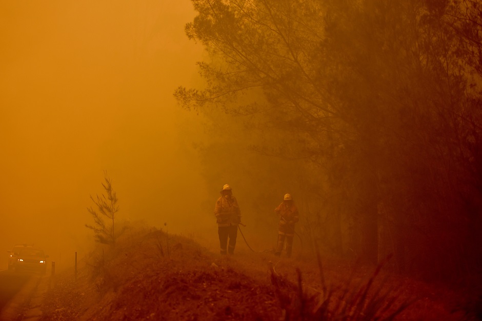 Firefighters tackle a bushfire in thick smoke in the town of Moruya, south of Batemans Bay, Wales. PHOTO: AFP