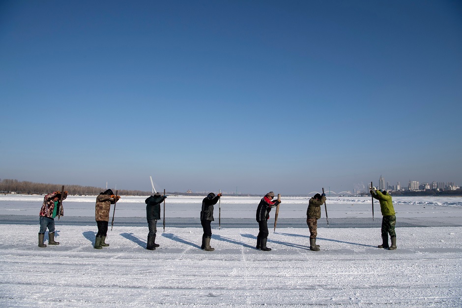 This photo taken on December 12, 2019 shows workers cutting into the ice to make blocks on the frozen Songhua river in Harbin, in China's northeastern Heilongjiang province ahead of the Harbin International Ice and Snow Festival. PHOTO: AFP