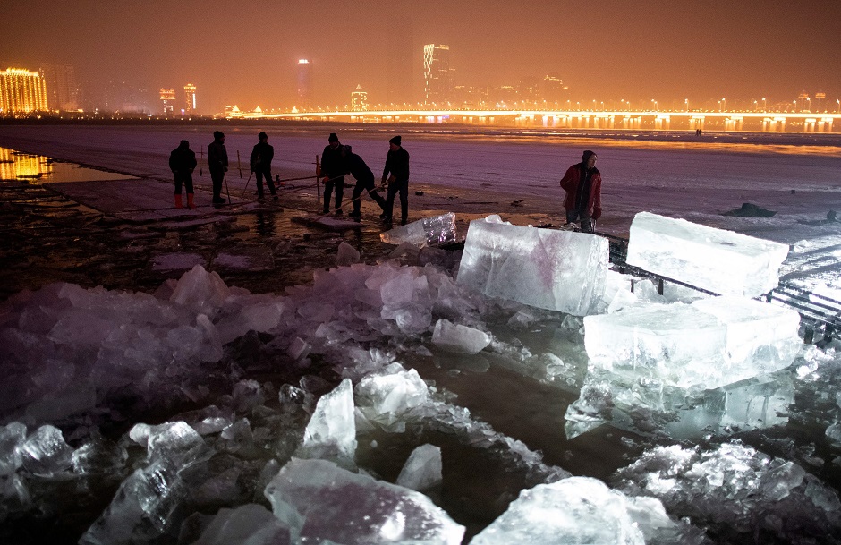 7.This photo taken on December 10, 2019 shows workers carving up ice blocks on the frozen Songhua river in Harbin, in China's northeastern Heilongjiang province ahead of the Harbin International Ice and Snow Festival. PHOTO: AFP