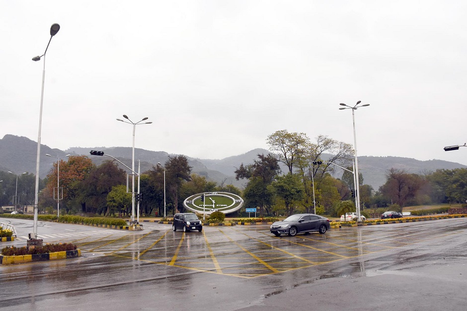 Motorists are on their way during the cold rainy weather on Margalla Road in federal capital. PHOTO ONLINE 