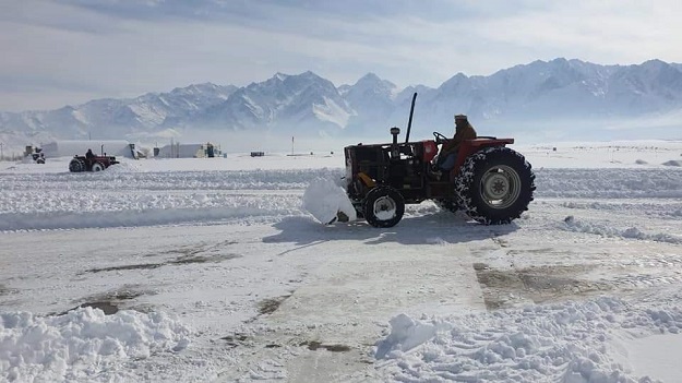 A man operating a tractor trolley can be seen removing snow at the Skardu Airport .PHOTO: EXPRESS