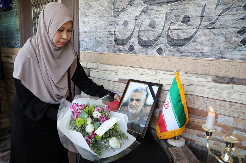 A woman offers flowers during a condolence ceremony for Iranian Major-General Qassem Soleimani, who was killed in a airstrike near Baghdad, outside the Embassy of Iran in Kuala Lumpur. PHOTO: Reuters