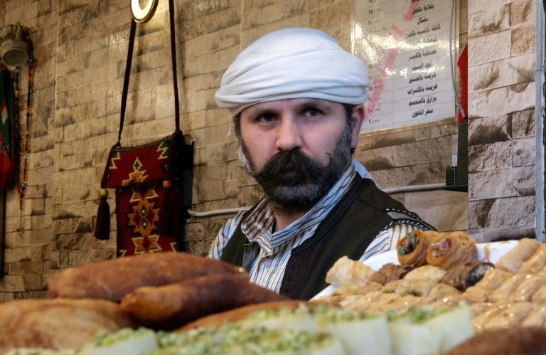 This Syrian Kurdish man sells sweets at a shop in Arbil. PHOTO: AFP