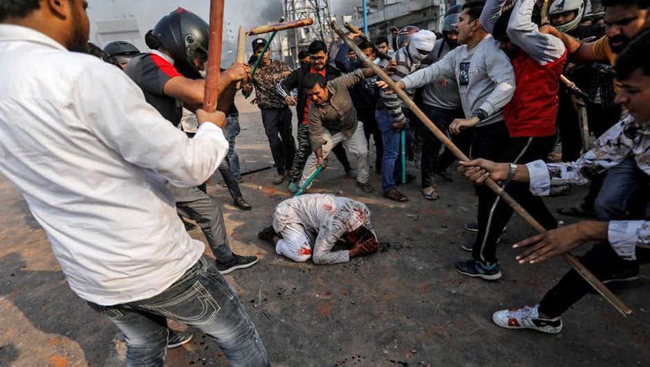 People supporting the new citizenship law beat a Muslim man during a clash with those opposing the law in New Delhi, India, February 24. PHOTO: REUTERS