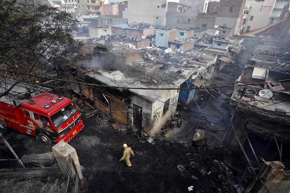 A firefighter walks past damaged shops at a tyre market after they were set on fire by a mob in a riot affected area after clashes erupted between people demonstrating for and against a new citizenship law in New Delhi, India, February 26, 2020. PHOTO: REUTERS