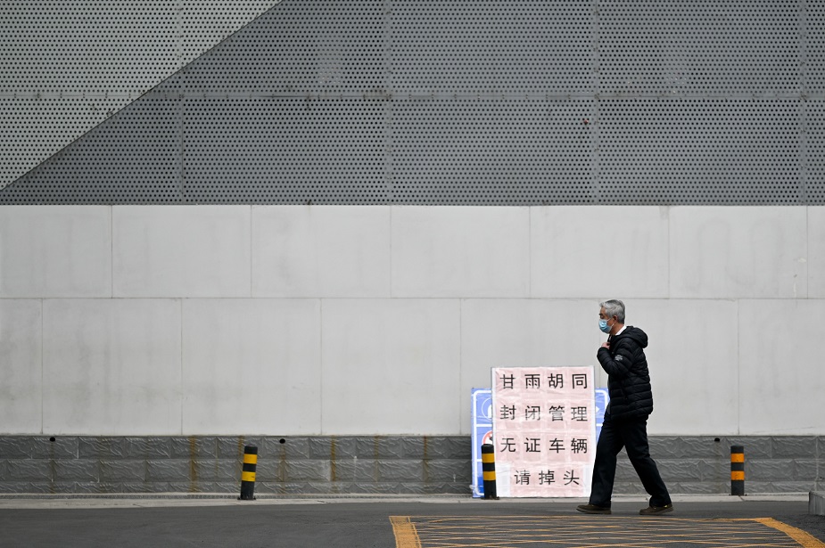 An elderly man wearing a face mask walks along a road in Beijing on February 25, 2020. - The new coronavirus has peaked in China but could still grow into a pandemic, the World Health Organization warned, as infections mushroom in other countries. PHOTO: AFP