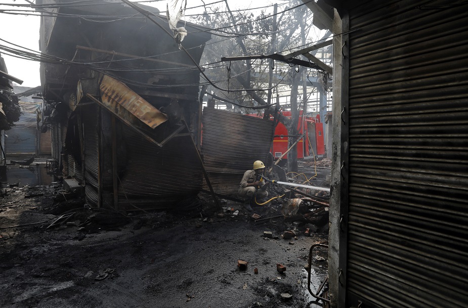 A firefighter douses the burning wreckage of a shop at a tyre market after it was set on fire by a mob in a riot affected area after clashes erupted between people demonstrating for and against a new citizenship law in New Delhi, India, February 26, 2020. PHOTO: REUTERS
