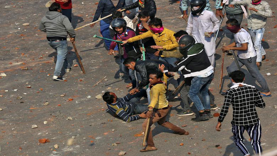 A man is beaten during a clash between people supporting a new citizenship law and those opposing the law in New Delhi, February 24. PHOTO: REUTERS