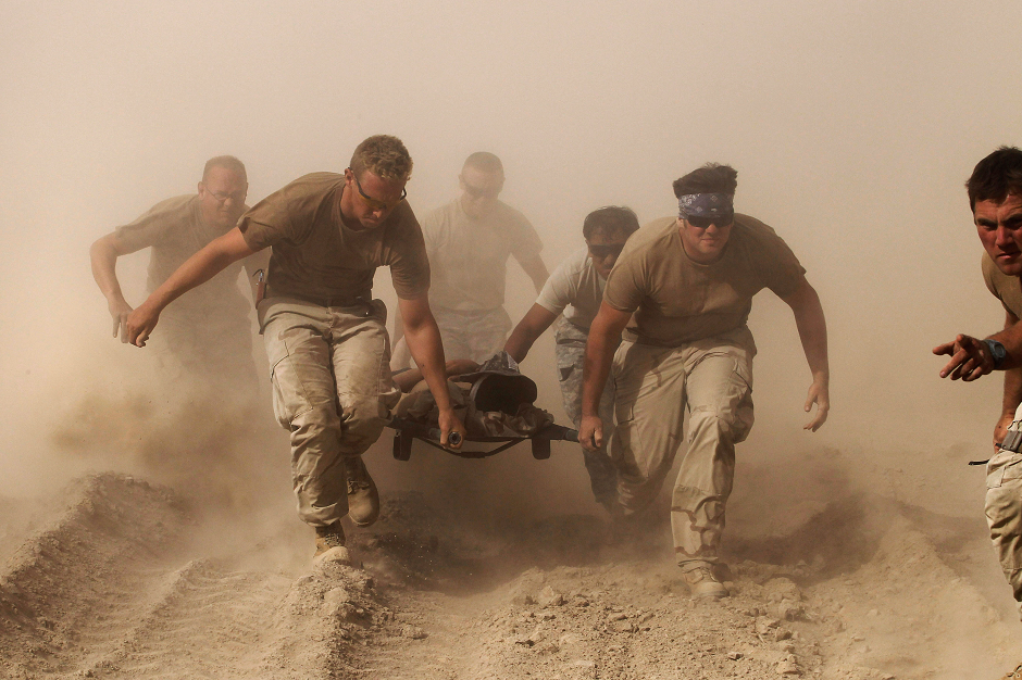 Members of the US Navy carry a comrade wounded by an explosion to a medevac helicopter in Kandahar province in southern Afghanistan October 2, 2010. PHOTO: REUTERS