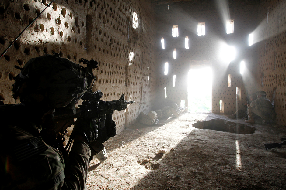 US soldier Nicholas Dickhut from 5-20 infantry Regiment attached to 82nd Airborne points his rifle at a doorway after coming under fire by the Taliban while on patrol in Zharay district in Kandahar province, southern Afghanistan April 26, 2012. PHOTO: REUTERS