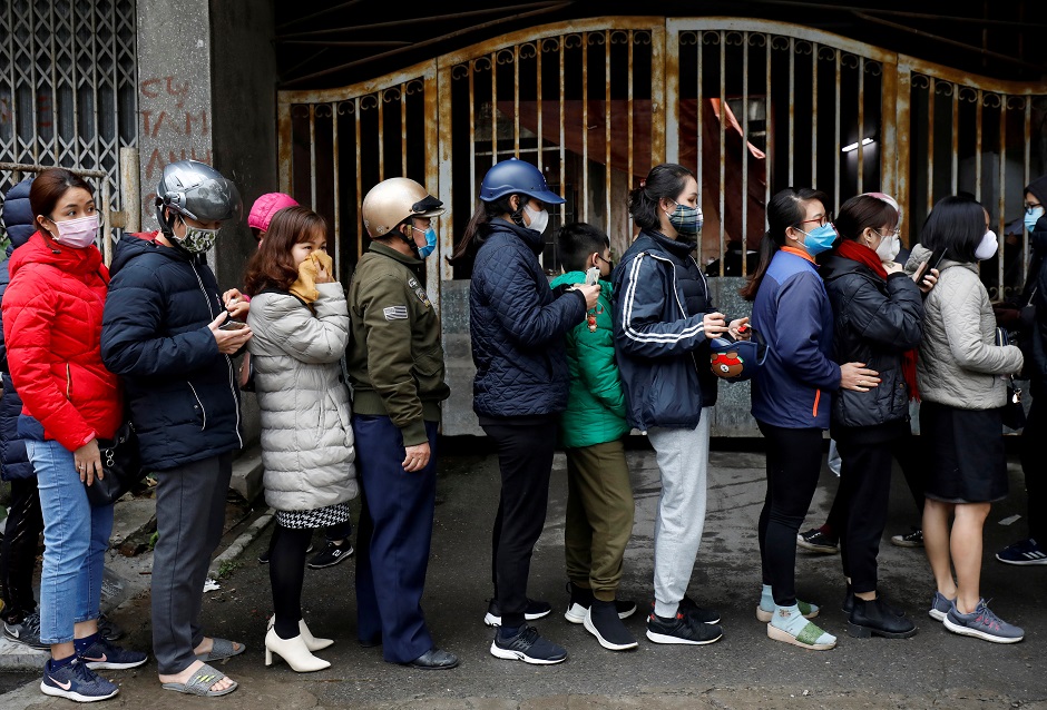 People line up to buy protective masks at a shop in Hanoi, Vietnam. PHOTO: Reuters