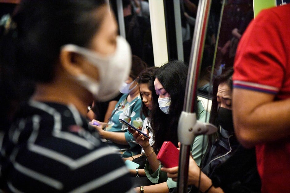 This photo shows people wearing protective facemasks, amid concerns of the COVID-19 coronavirus outbreak, on public transport during the morning commute in Bangkok. PHOTO: AFP