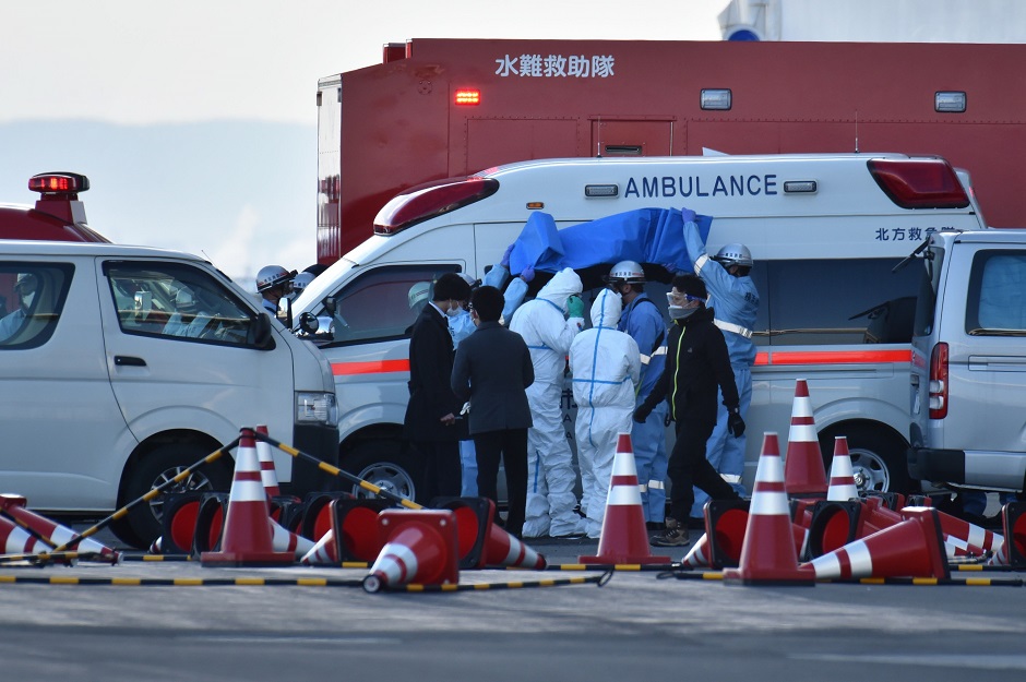 Personnel clad in protective gears and tasked to provide care for suspected patients on board the Diamond Princess cruise ship, prepare to leave an ambulance at the Daikoku Pier Cruise Terminal in Yokohama. PHOTO: AFP