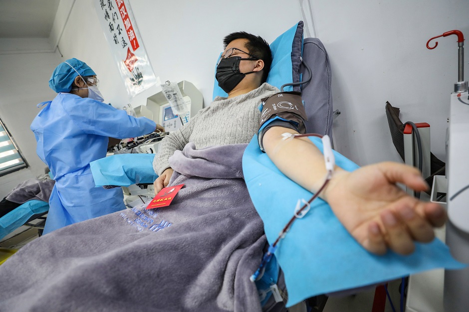 This photo shows a doctor (R) who has recovered from the COVID-19 coronavirus infection donating plasma in Wuhan in China's central Hubei province. PHOTO: AFP