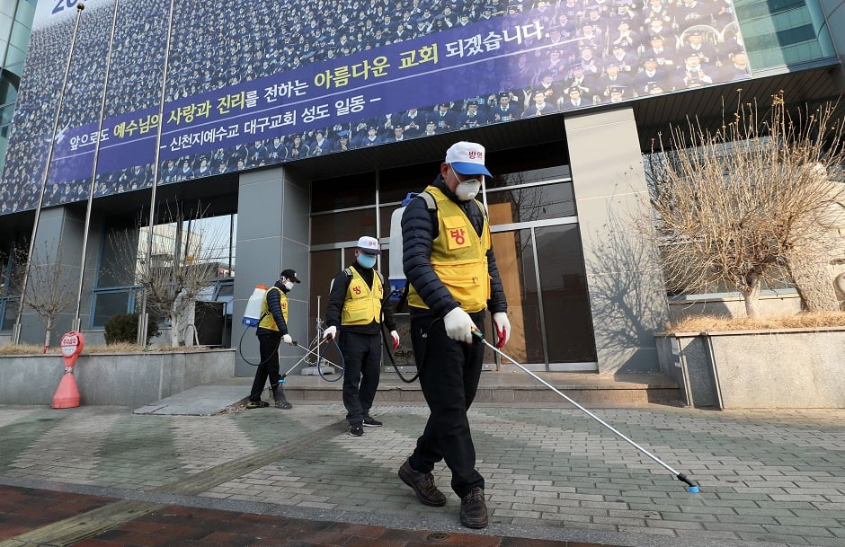 South Korean health officials spray disinfectant in front of the Daegu branch of the Shincheonji Church of Jesus in the southeastern city of Daegu as about 40 new cases of the COVID-19 coronavirus confirmed after they attended same church services. PHOTO: AFP