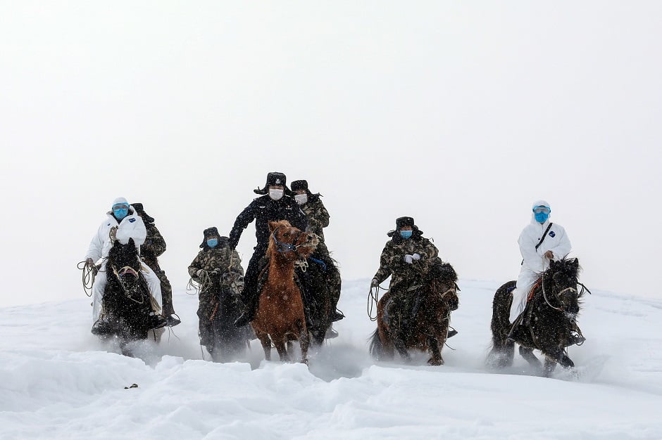 This photo shows police officers wearing protective face masks riding horses on their way to visit residents who live in remote areas in Altay, farwest China's Xinjiang region, to promote the awareness of the virus. PHOTO: AFP