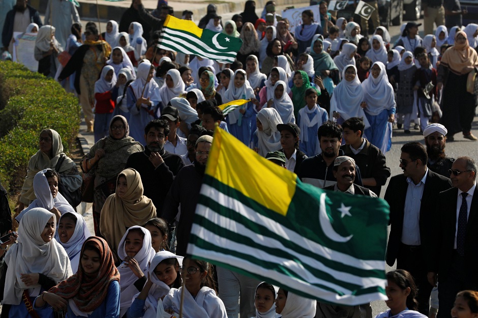 Students and teachers carry Azad Kashmir flags as they attend a march to mark Kashmir Solidarity Day. PHOTO: Reuters