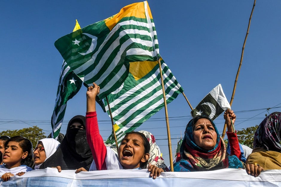 Protesters hold Kashmiri flags as they gather in front of the mausoleum in Karachi. PHOTO: AFP