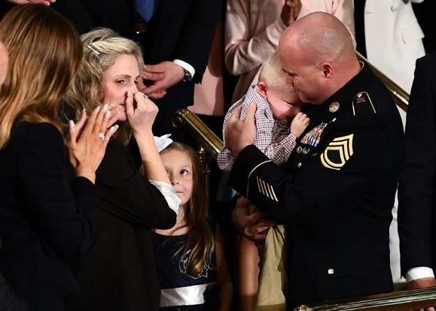 Sgt Townsend Williams, returning from deployment in Afghanistan, was reunited with his wife Amy and baby son during the State of the Union address. PHOTO: AFP