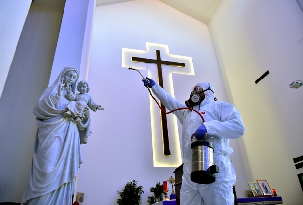 Sanitary workers disinfect a church in Beirut, Lebanon. PHOTO: AFP
