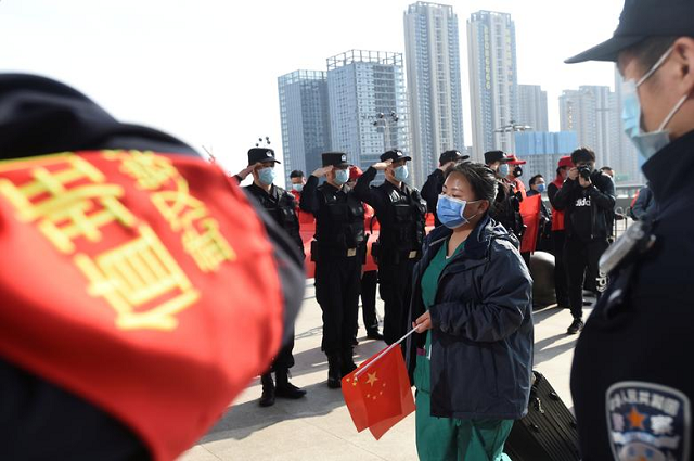 Police officers salute as a medical worker from outside Wuhan arrives at the Wuhan Railway Station before leaving the epicenter of the coronavirus outbreak, in Hubei province, China. PHOTO: Reuters