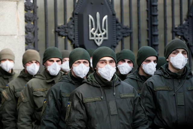 Members of the National Guard of Ukraine wearing protective face masks stand guard in front of the Ukrainian parliament building amid coronavirus concerns in Kiev, Ukraine. PHOTO: Reuters
