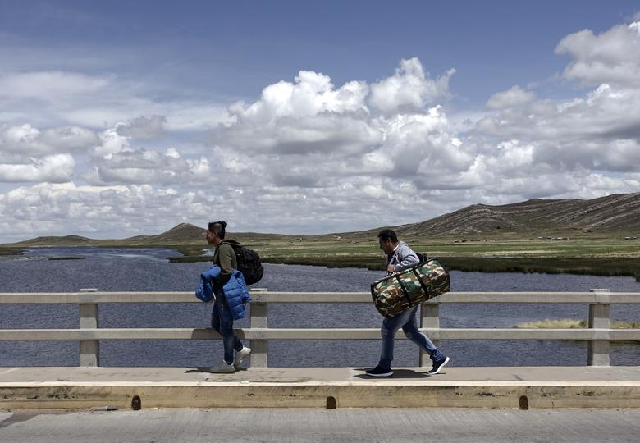Stranded passengers cross the international bridge at the border between Peru and Bolivia, after Peru's government's announcement of the border closure in a bid to slow the spread of the new coronavirus. PHOTO: Reuters