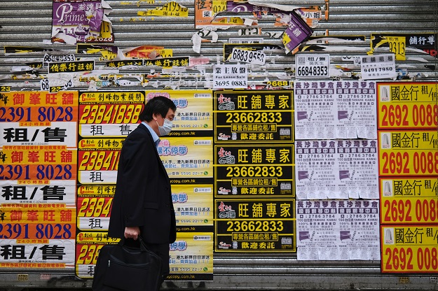 A man wearing protective mask walks past a closed shop covered with advertisements for rental space at Mongkok, following the outbreak of the new coronavirus, in Hong Kong, China. PHOTO: Reuters