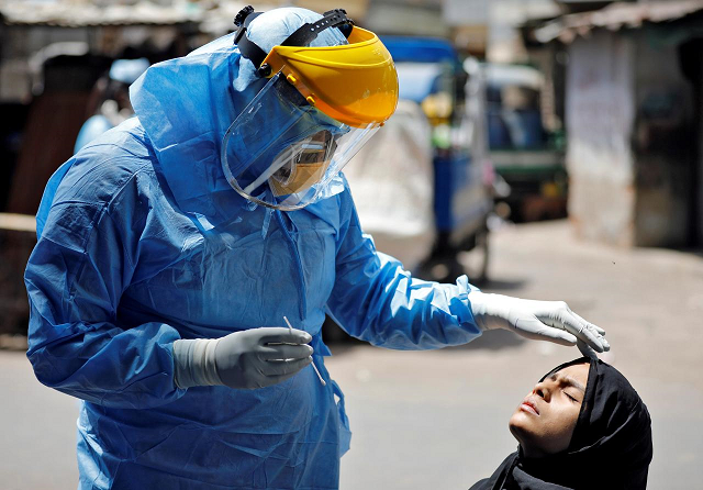 a doctor wearing a protective gear prepares to take a swab from a girl to test for the coronavirus disease covid 19 at a residential area in ahmedabad india april 8 2020 photo reuters