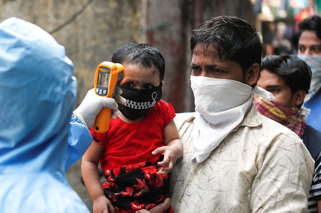 a doctor scans residents from dharavi one of asia 039 s largest slums with an infrared thermometer to check their temperature as a precautionary measure against the spread of the coronavirus disease covid 19 in mumbai india april 11 2020 photo reuters