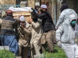 People move a coffin of a man who died due to coronavirus disease for a burial at graveyard in Abbottabad. PHOTO: REUTERS/FILE