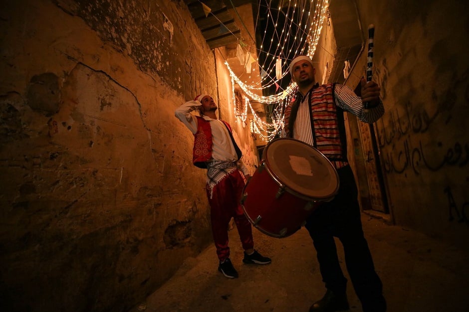Drummers wearing traditional clothes play and read folk poetry to wake people for the sahur meal, the last meal before a long day of fasting that starts with the call to prayer at sunrise during the holy month of Ramadan in Gaza City on April 24. PHOTO: Anadolu Agency