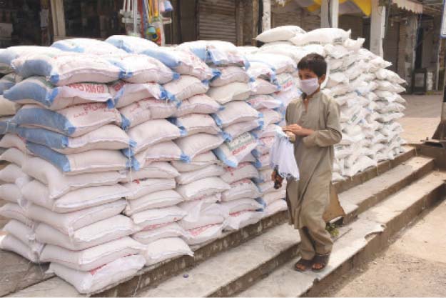 A child selling face masks walks past stocks of whole wheat flour in the capital. PHOTOS: ONLINE