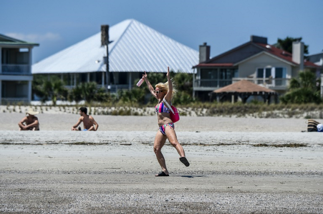 A woman dances on the beach at Tybee Island, Georgia after the state's governor ordered a partial reopening of businesses and public places. PHOTO: AFP