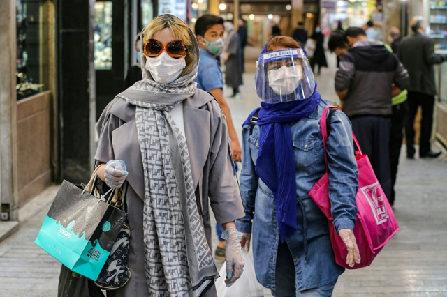 Shoppers clad in protective gear, including face masks and shields and latex gloves, walk through the Tajrish Bazaar in Iran's capital Tehran during the Muslim holy month of Ramadan. PHOTO: AFP