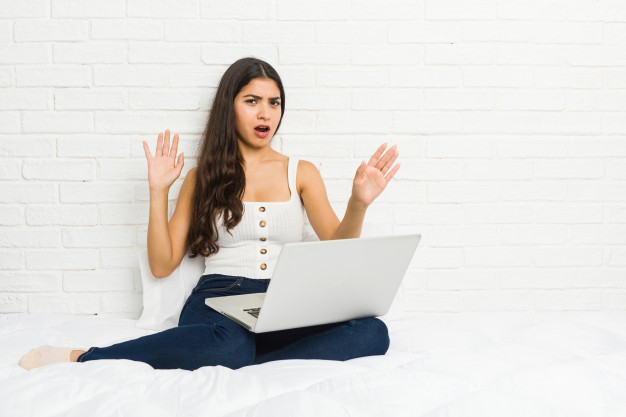 young-arab-woman-working-with-her-laptop-bed-being-shocked-due-imminent-danger_1187-32152