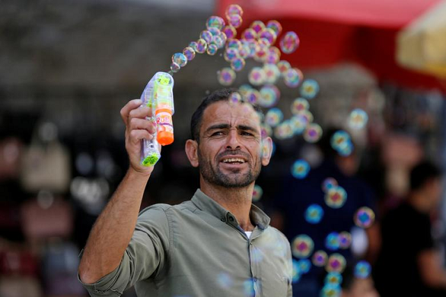 A Palestinian man releases soap bubbles at a market as Palestinians prepare for the upcoming holiday of Eidul Fitr marking the end of Ramadan in Bethlehem in the West Bank. PHOTO: Reuters