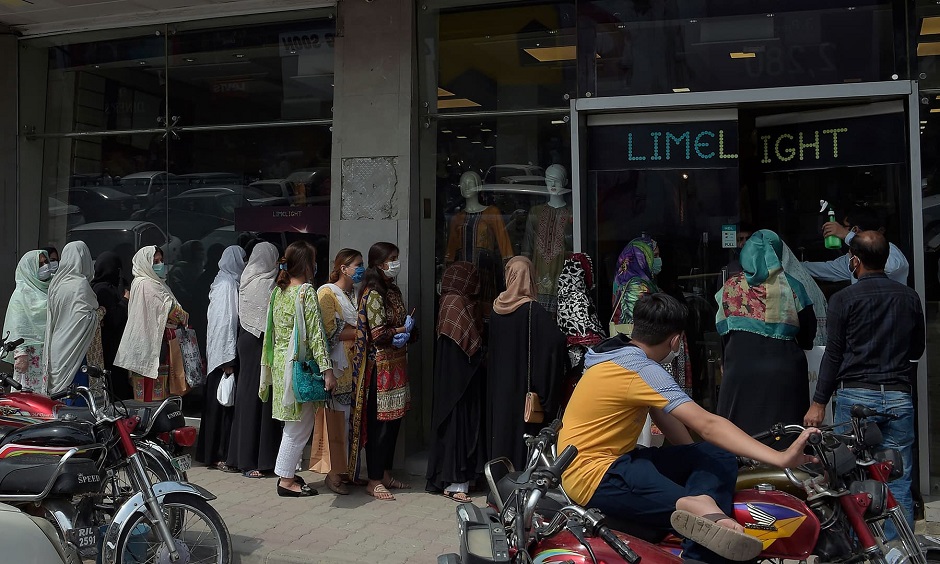 Women queue to enter a clothing store after the government eased the nationwide lockdown imposed as a preventive measure against the COVID-19 coronavirus, in Rawalpindi on May 11, 2020. (Photo by Farooq NAEEM / AFP)