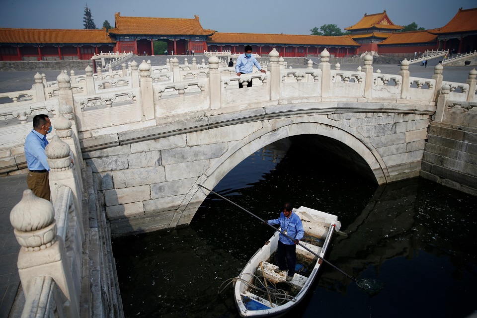 Staff members wearing face masks work at the Forbidden City as it reopens on the first day of the five-day Labour Day holiday following the coronavirus disease (COVID-19) outbreak, in Beijing, China May 1, 2020. REUTERS/Tingshu Wang