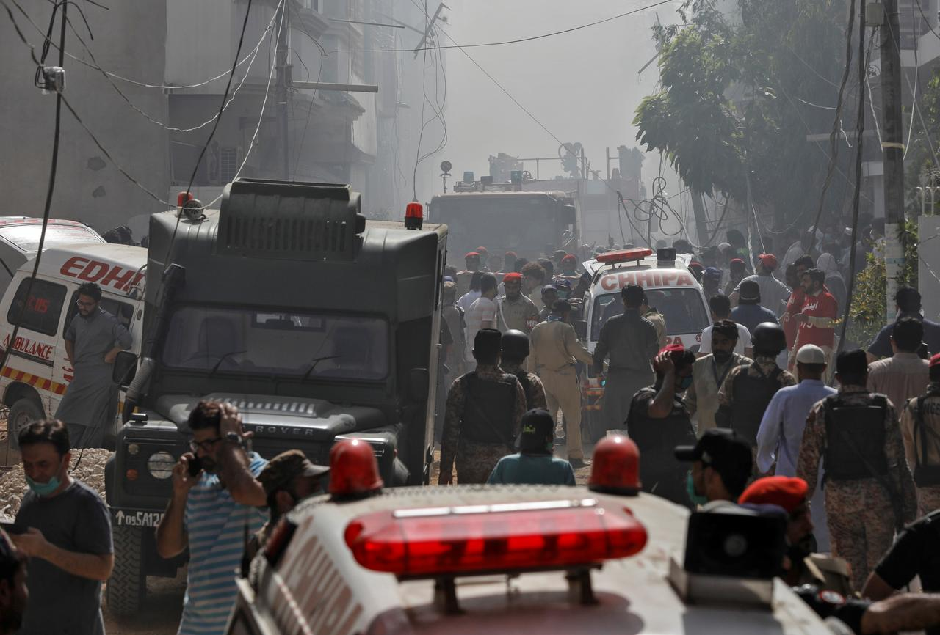 Ambulances and fire brigade vehicles gather at the site of a passenger plane crash in a residential area near an airport in Karachi. PHOTO: REUTERS