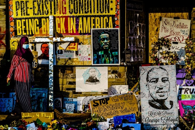 A woman walks past a makeshift memorial to George Floyd near the site where he died in police custody in Minneapolis, Minnesota. PHOTO: AFP 