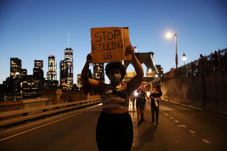 A protester holds a sign reading 